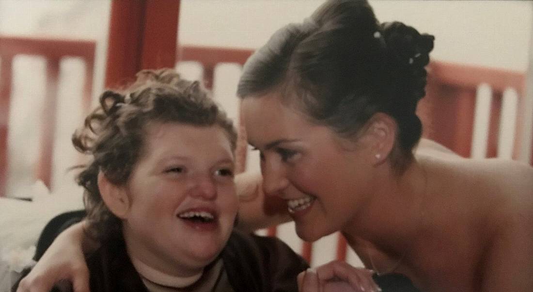 A photograph of Jackie Dolan with her sister laughing together at a family event.