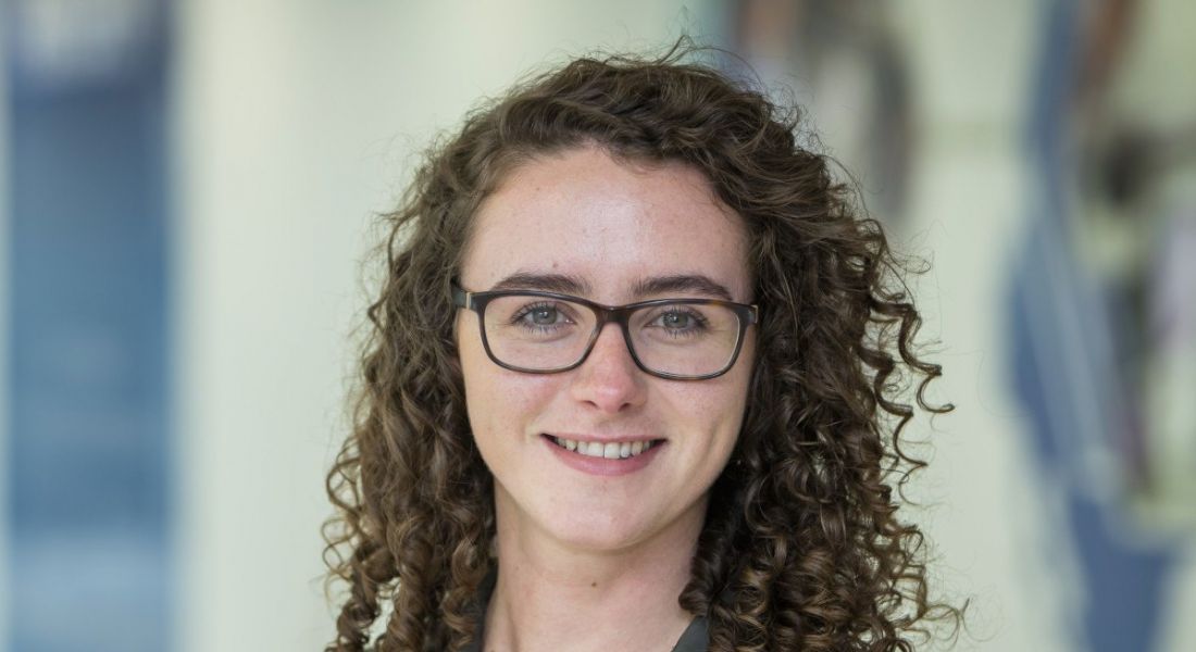 Kate Madigan of Amgen is wearing glasses and smiling into the camera.