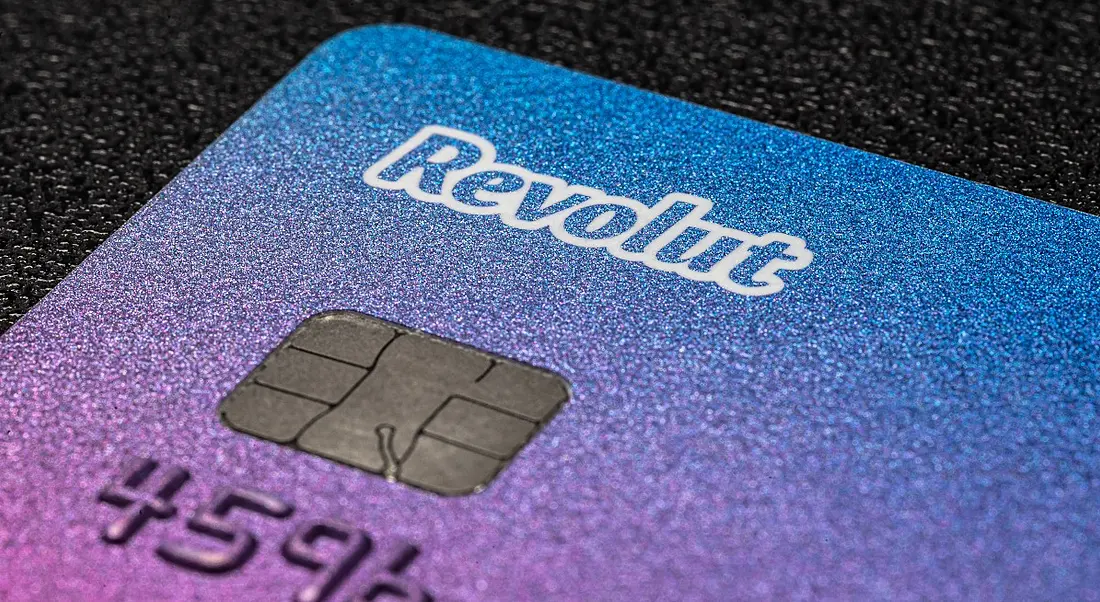 Close-up of a Revolut bank card on a dark surface.