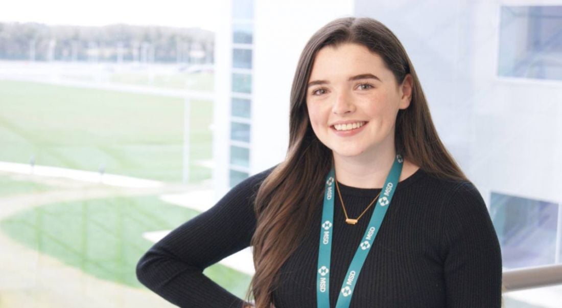 Aoife Dillon of MSD is standing in front of a window and smiling into the camera.