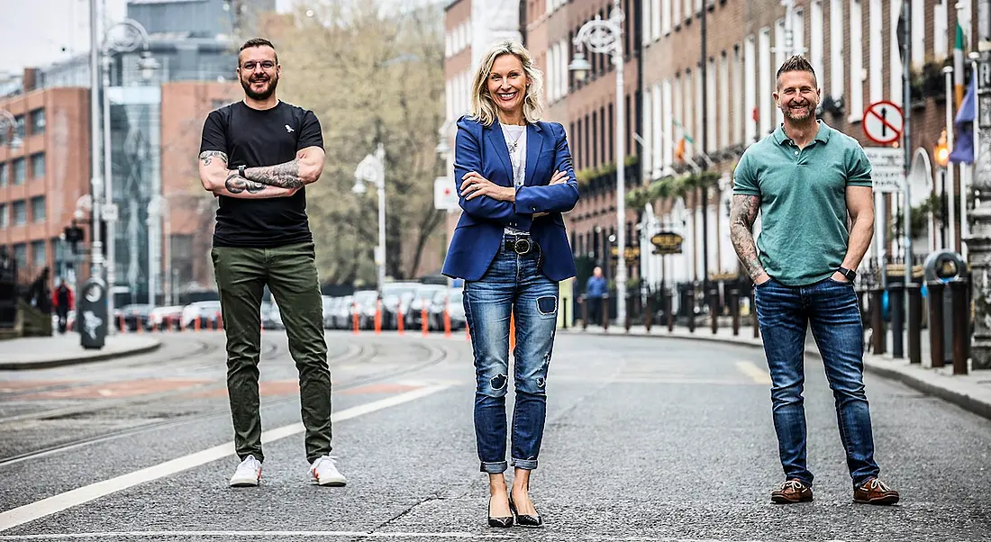 Two men and one woman are standing together on a street in Dublin to mark a new investment in Lucky Beard.