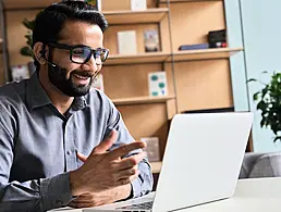 Graphic image of a woman meditating with a laptop and a plant on either side of her and cartoon icons of emails and notes orbiting around her head.