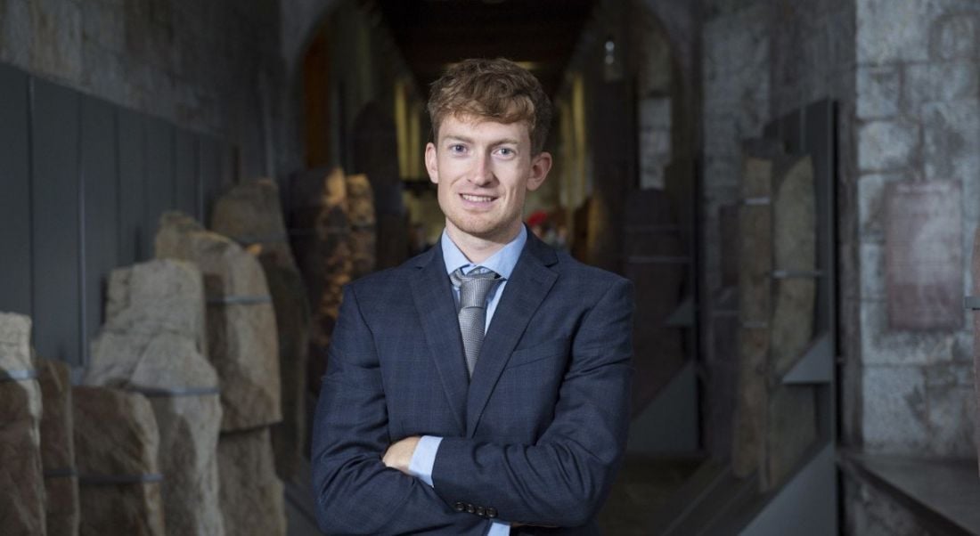 Conor Lyden of Trustap stands in a suit with arms crossed smiling at the camera.