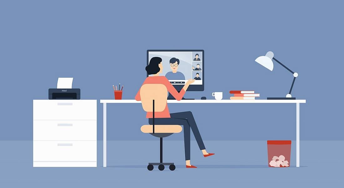 Cartoon graphic of a woman working at a desk as she talks to someone on the screen, symbolising hybrid working.