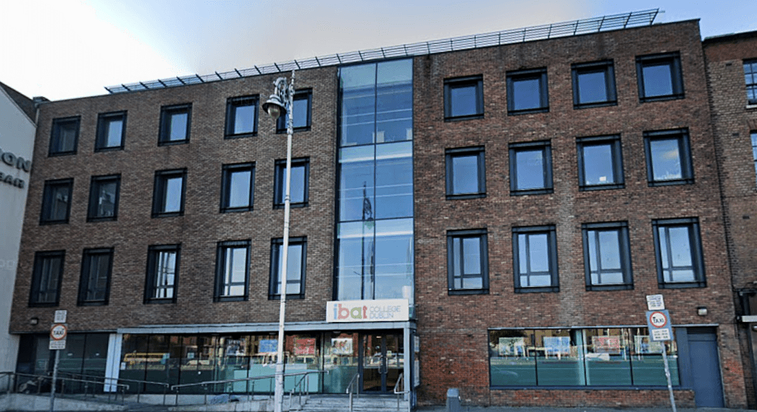 A view of IBAT College Dublin from across the street. It shows a large, brown brick building with 27 windows.