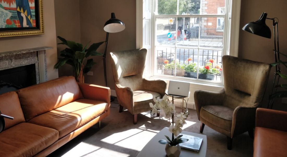 Thrive Global's Dublin office, featuring couches in a ground floor conference room and a view of Mount Street Upper.