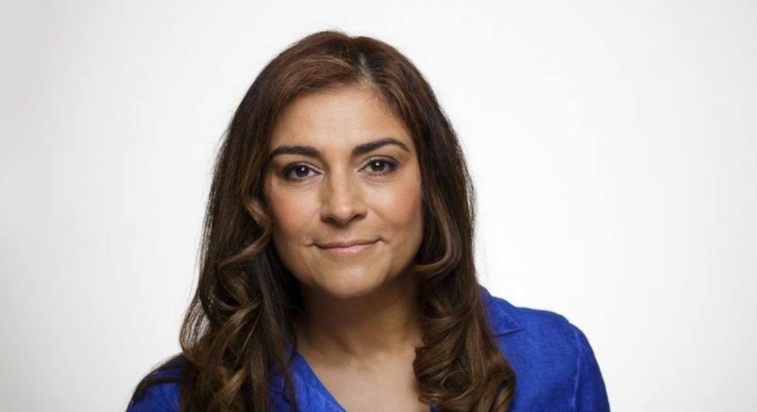 A woman wearing a blue blouse pictured against a white background.