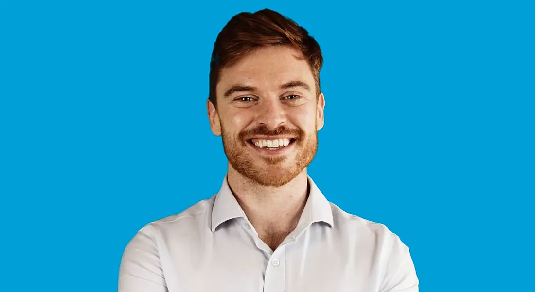 TJ Hegarty, founder of online tutoring business Breakthrough Maths pictured against a blue background.