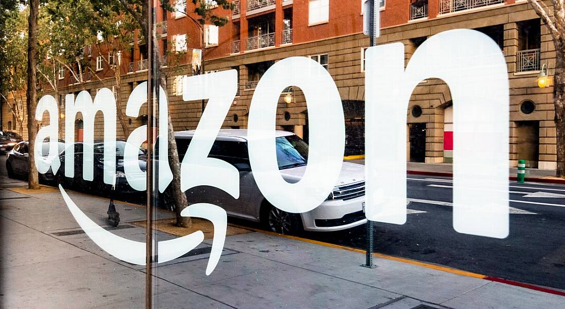 Amazon logo reflected in a glass shopfront window.