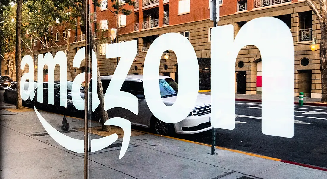 Amazon logo reflected in a glass shopfront window.