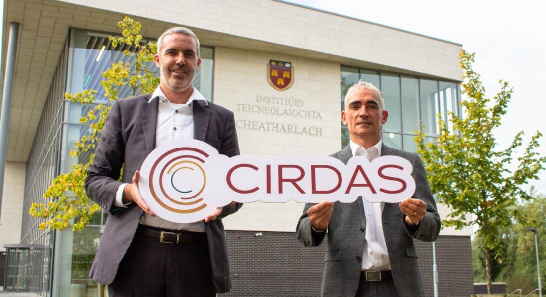 Two men stand outside IT Carlow, holding a sign that says 'CIRDAS'.