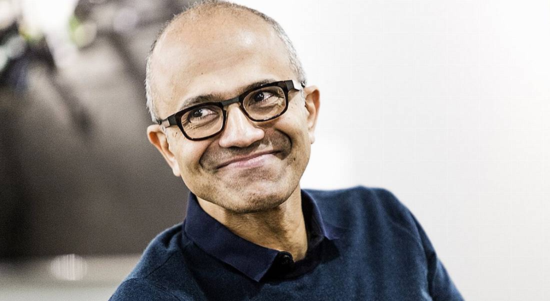 CEO of Microsoft, Satya Nadella, smiling while looking off camera.