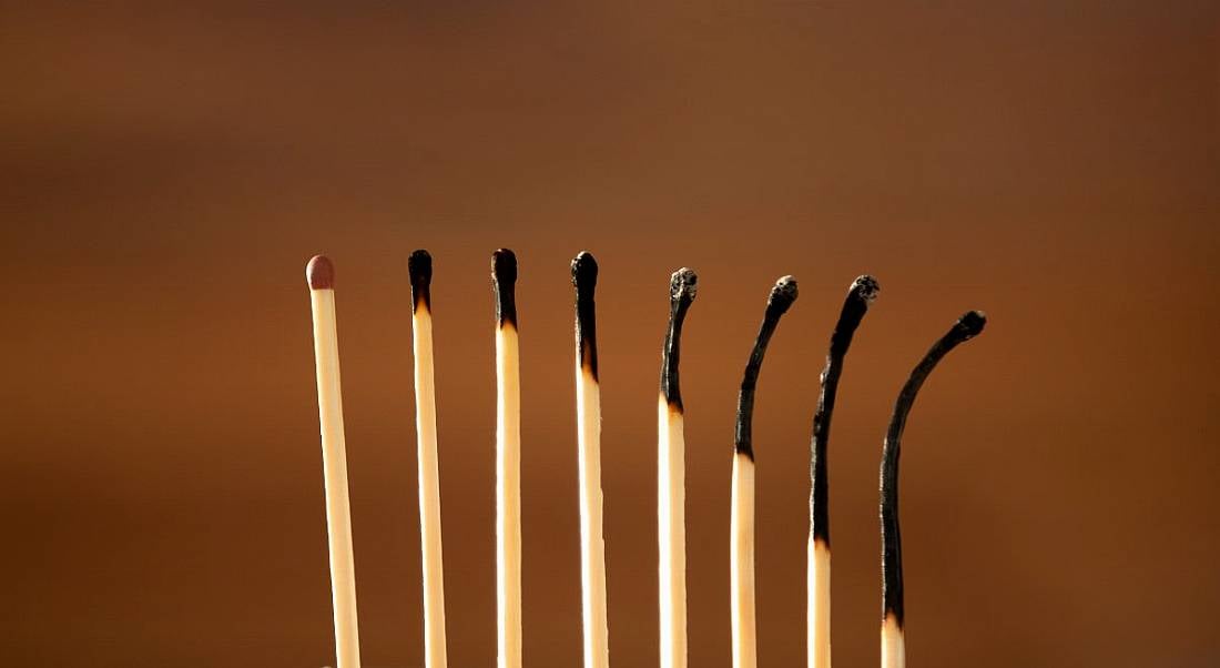 A row of eight matches, the first in good condition but the rest gradually becoming more burnt, symbolising burnout.