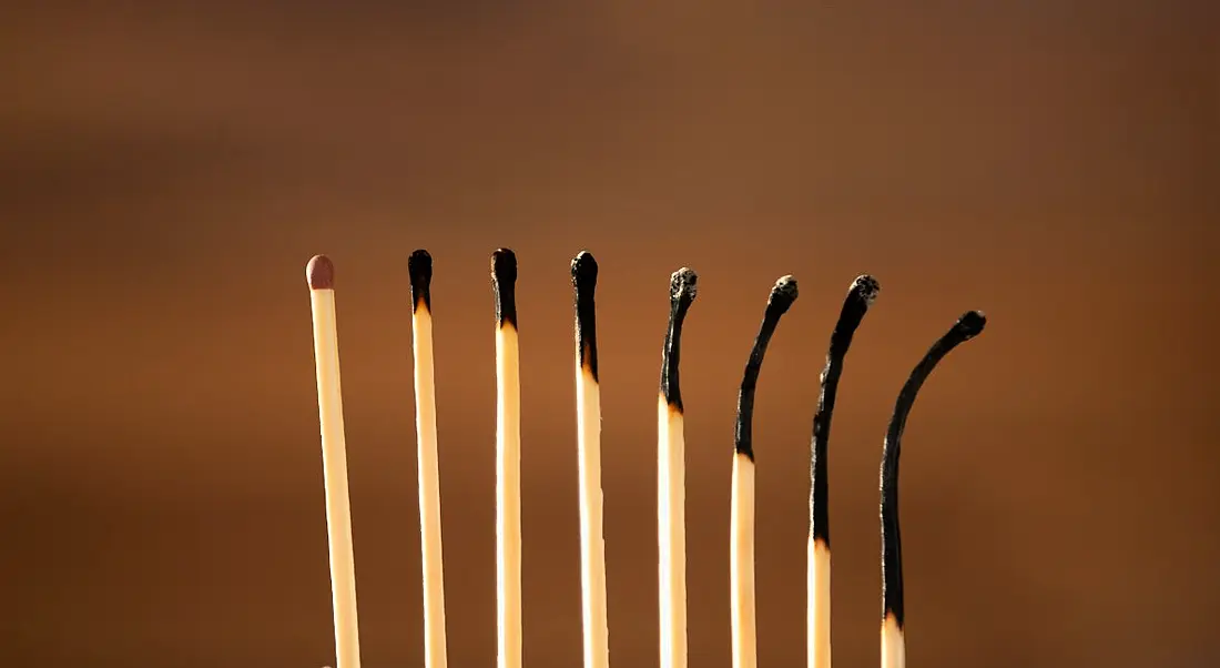 A row of eight matches, the first in good condition but the rest gradually becoming more burnt, symbolising burnout.