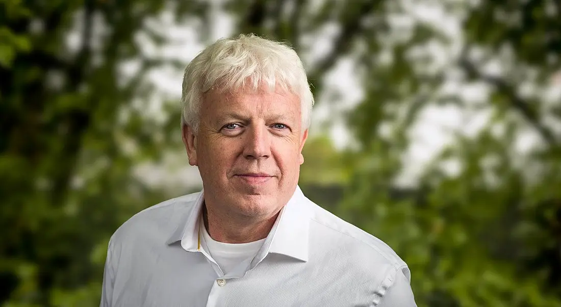 A man in a white shirt smiling at the camera against an out-of-focus background of trees. He is Paul Phelan, CEO of Data Edge.