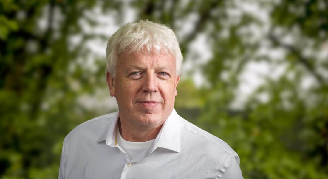 A man in a white shirt smiling at the camera against an out-of-focus background of trees. He is Paul Phelan, CEO of Data Edge.