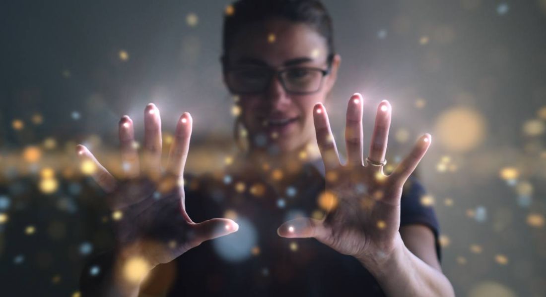 A woman wearing glasses is interacting with a digital interface at work.