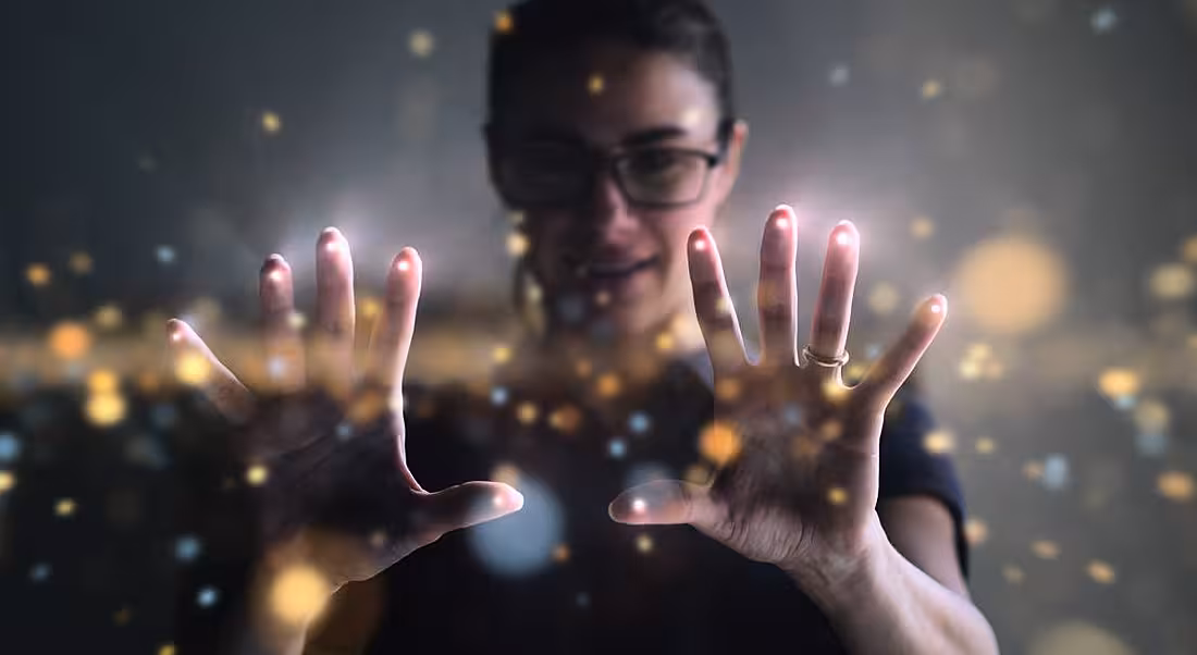 A woman wearing glasses is interacting with a digital interface at work.