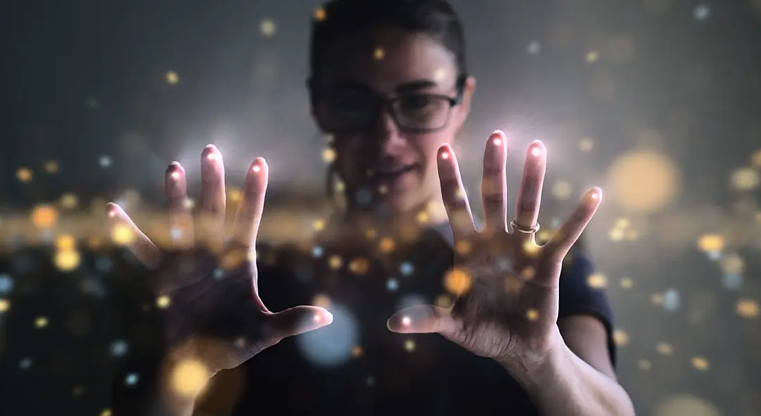 A woman wearing glasses is interacting with a digital interface at work.