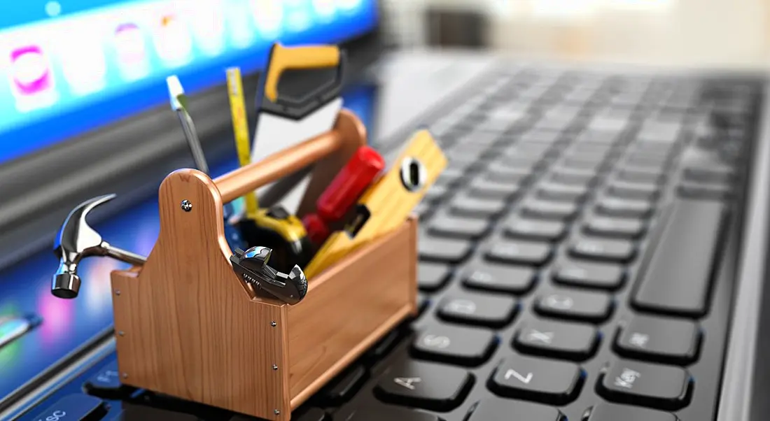 A mini toolbox resting on a computer keyboard.