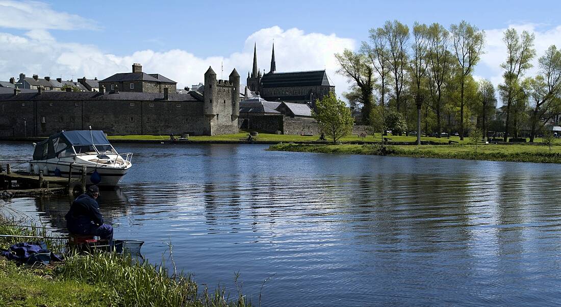 Photograph of a man fishing at a lake beside Enniskillen Castle, Co Fermanagh.