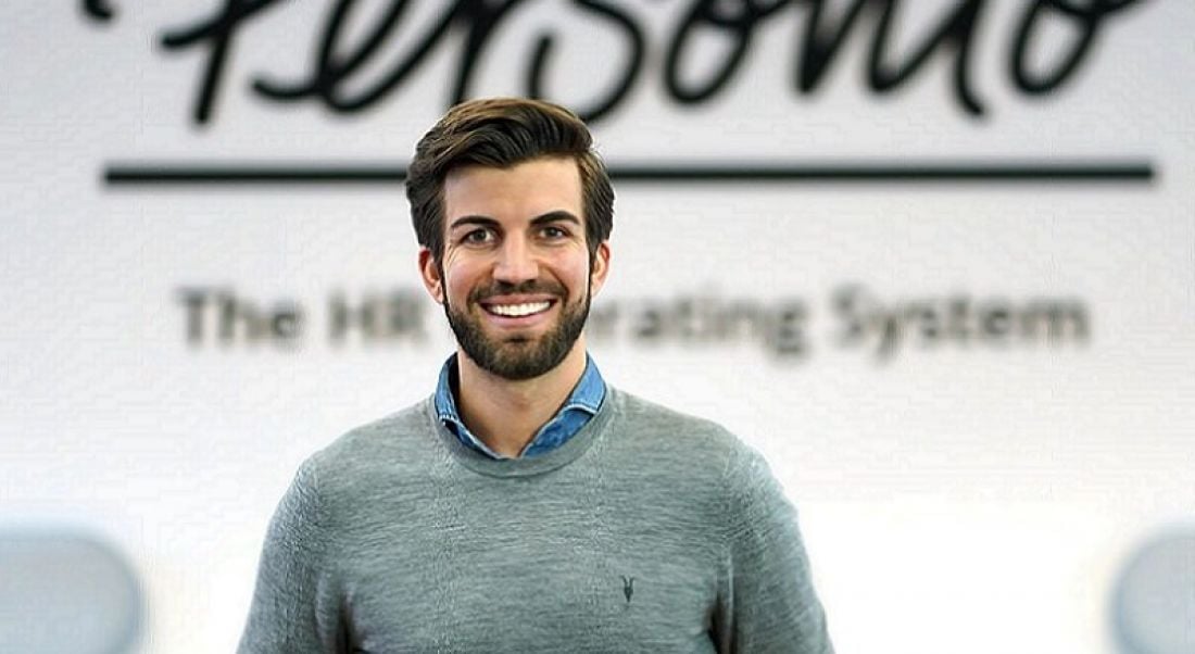 Chief executive of Personio Hanno Renner is standing in front of a wall that bears the company’s name.