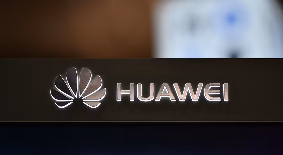 A backlit Huawei logo on a dark surface.