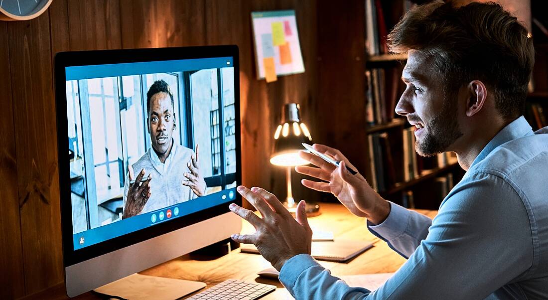 Two men are talking on a video call while working remotely.