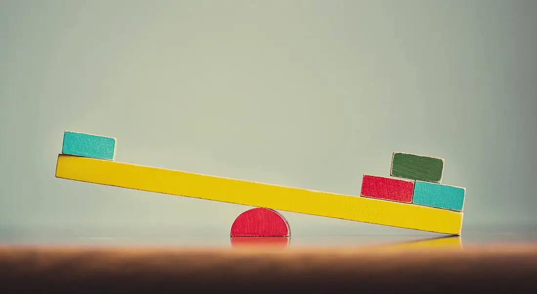 A colourful wooden seesaw is unbalanced.