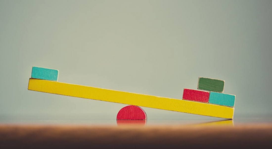 A colourful wooden seesaw is unbalanced.