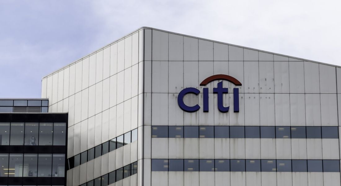 Office building with a Citi sign on the front against a cloudy blue sky.