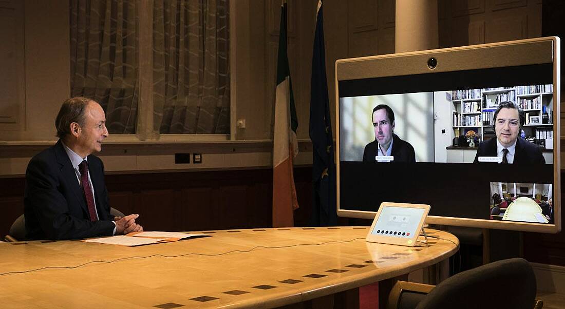 Micheál Martin sits at a conference room table in Government buildings, looking at a large screen for a video call with Martin Shanahan and Eamonn Sinnott.