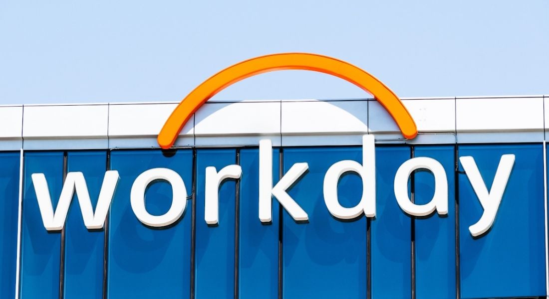 The Workday logo at the top of a tall glass office building against a bright blue sky.