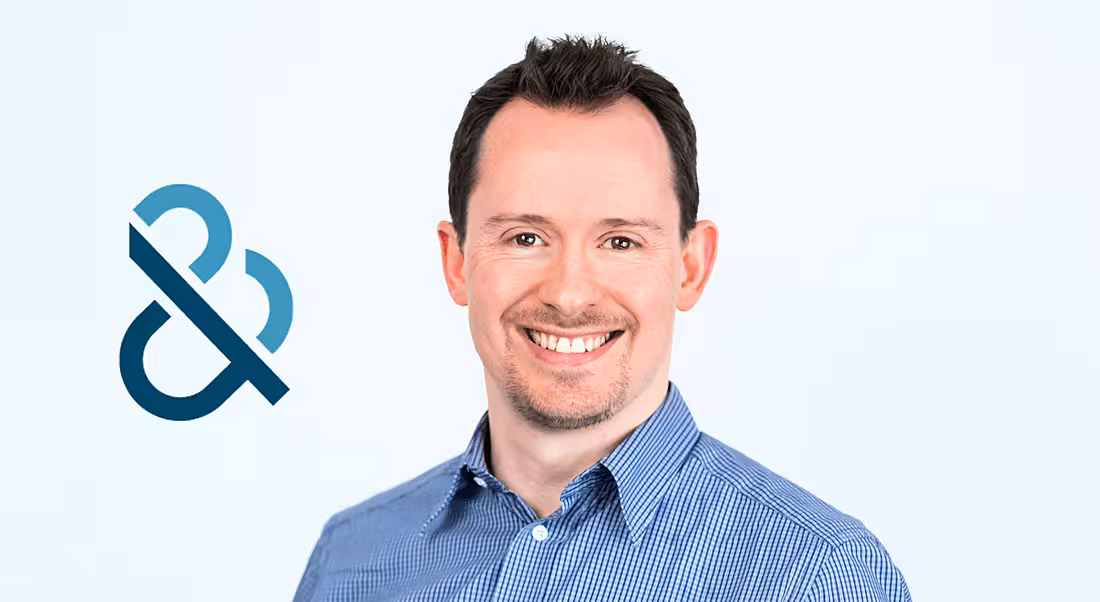 Paul Hitz of Dun & Bradstreet is smiling into the camera with the company logo behind him.