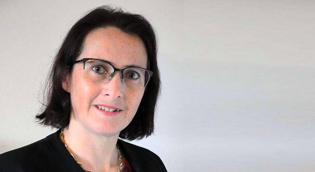 Helene Dingreville of EY is wearing glasses and smiling into the camera against a plain white background.