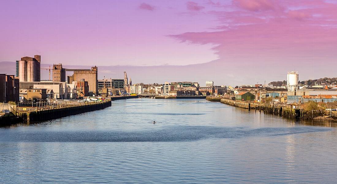 A panoramic view of the harbour in Cork city centre in the morning, with buildings either side.