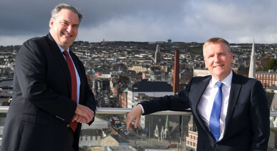 ActionZero’s Denis Collins with Michael McGrath standing on a balcony overlooking Cork city from the company's new office.