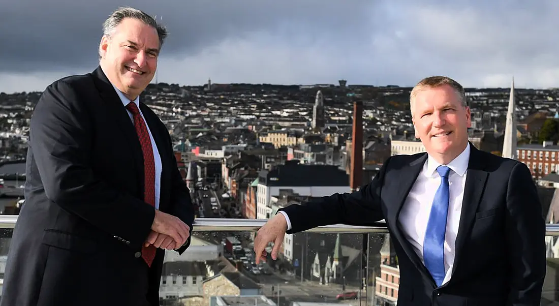 ActionZero’s Denis Collins with Michael McGrath standing on a balcony overlooking Cork city from the company's new office.