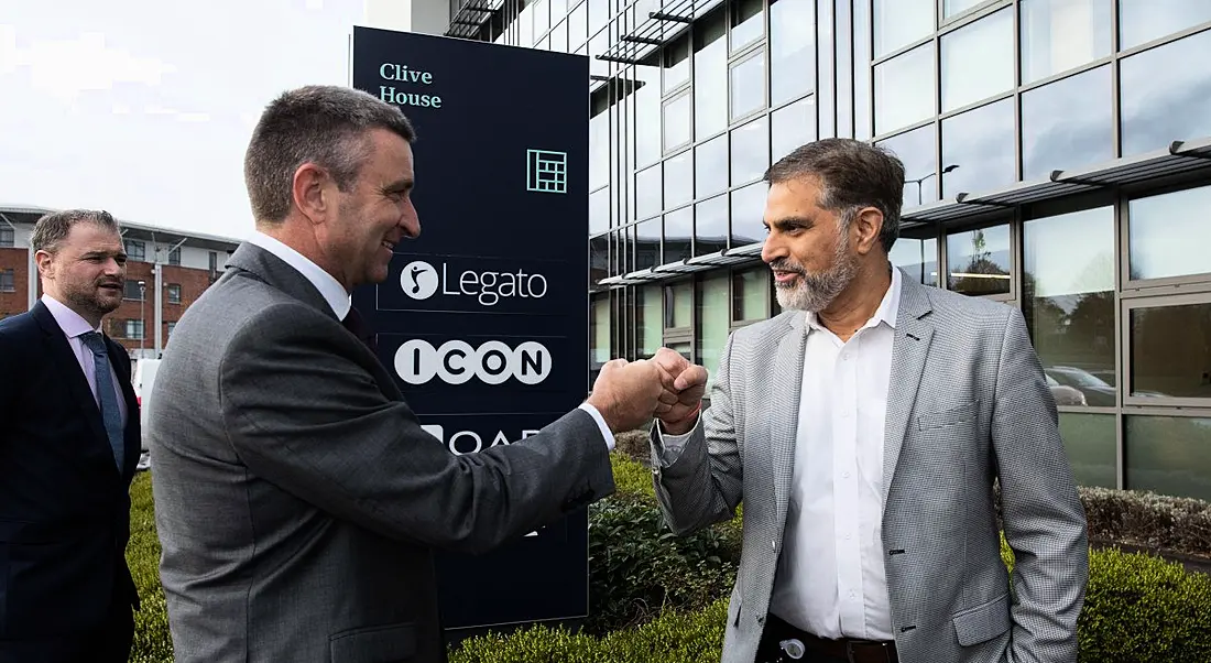 Minister Niall Collins, TD fist bumping Legato president Rajat Puri outside the company's new Limerick R&D hub.