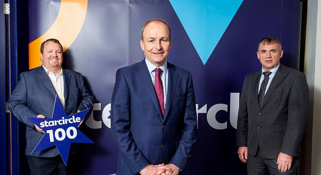 James Galvin, Micheál Martin and Martin Corkery standing in a row, with Galvin on the left holding a star-shaped sign with the Starcircle branding on it.