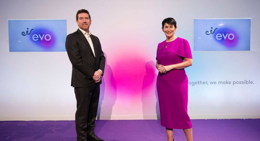 Martin Wells, managing director of Eir Evo, and Carolan Lennon, CEO of Eir, standing against a white background with two screens bearing the Eir Evo logo.