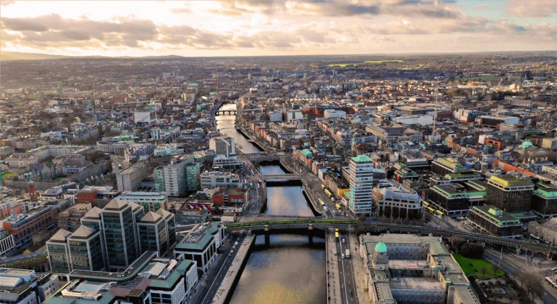 An aerial view over the city of Dublin, with the River Liffey going down the centre of the image.
