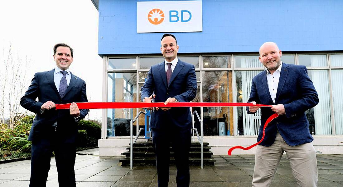 Three men are cutting a ribbon to mark the opening of a BD facility.