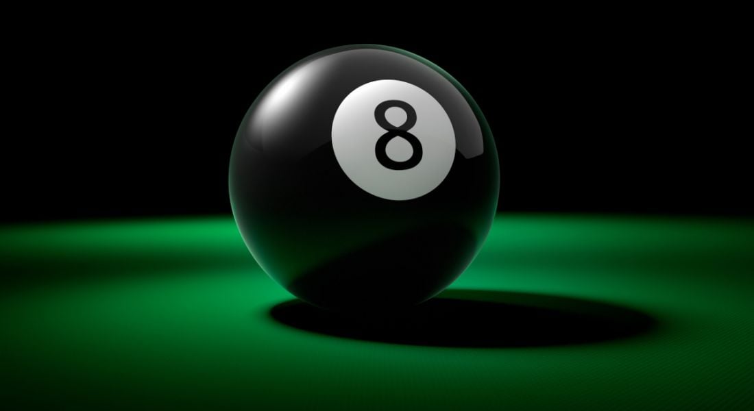 A black eight ball on a green pool table.