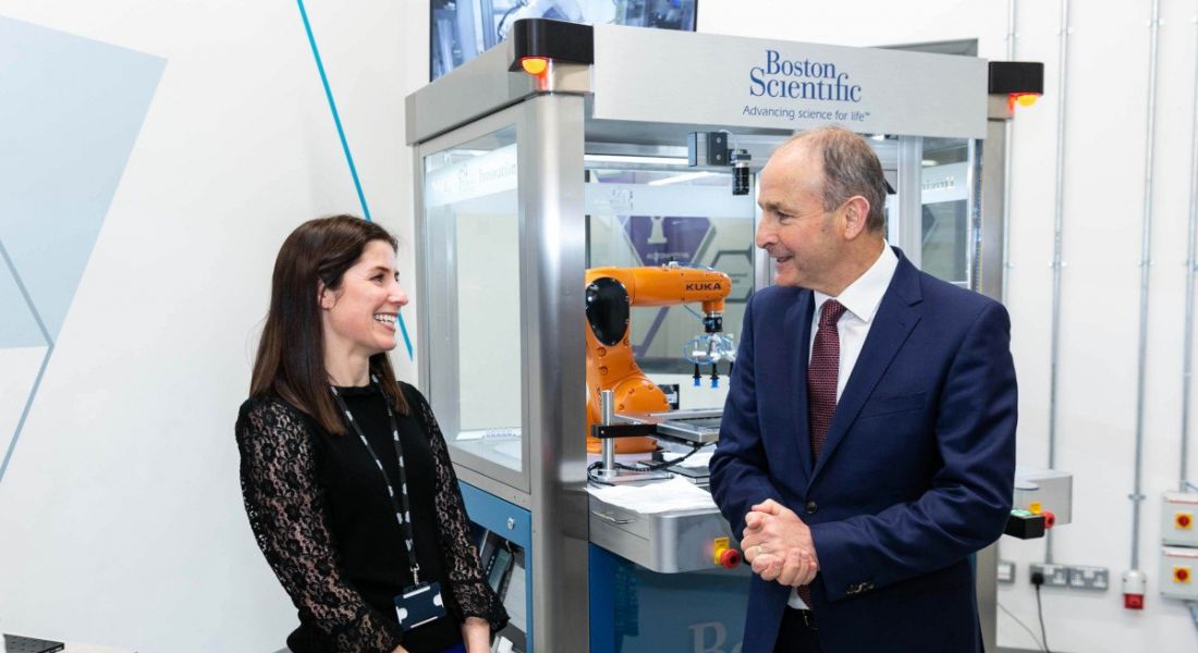 Taoiseach Micheál Martin and Niamh Hanney stand in front of a piece of Boston Scientific equipment at the company's base in Galway.