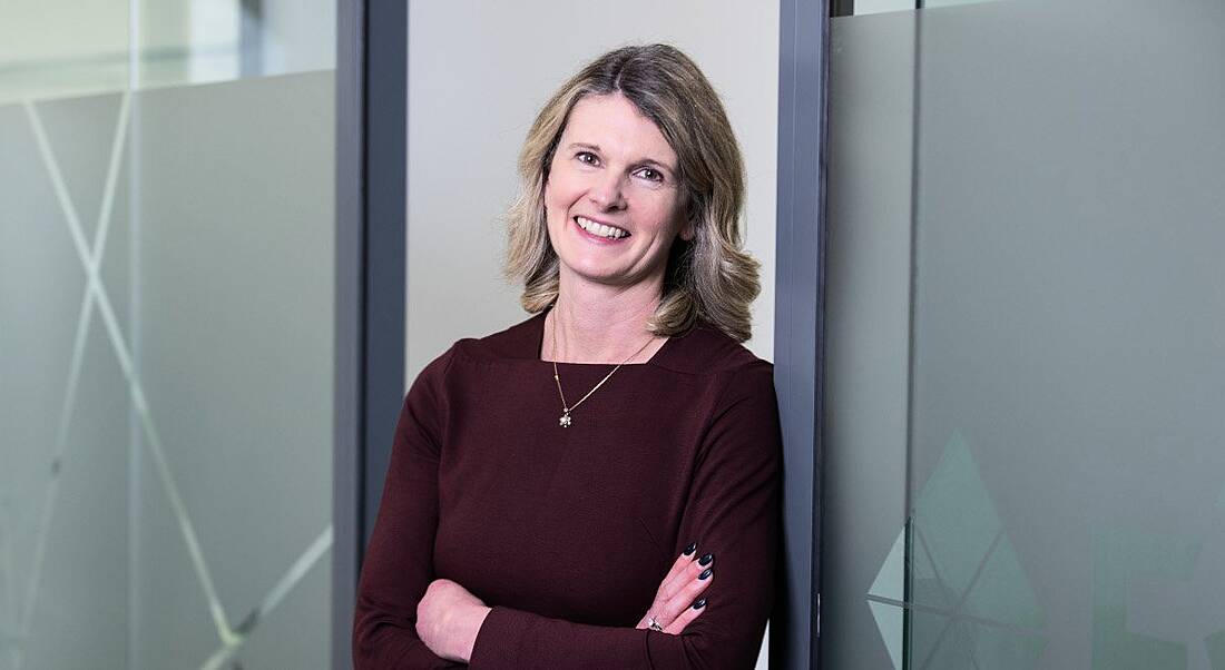 Eimhin O'Driscoll, life sciences recruitment expert, leaning against a glass doorway with her arms folded.