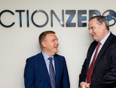 Minister for Public Expenditure and Reform Michael McGrath, TD, and ActionZero CEO Denis Collins with the ActionZero logo on a wall behind them.