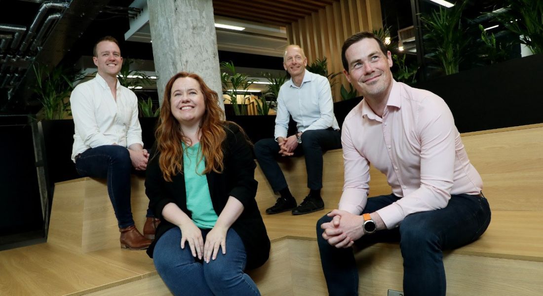 Ross Keating, VP of sales; Courtney Graham, VP of customer success; Mats Forsgren, VP operations; Dermot O'Connor, CEO eDesk sitting on some wooden steps in a group.