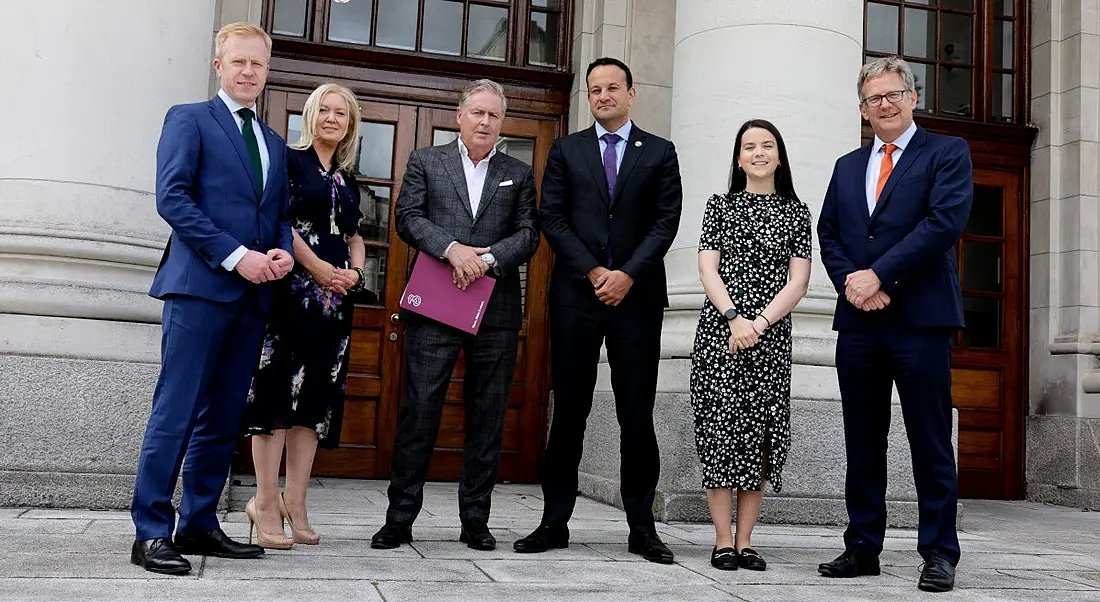 A group of people stand outside Government buildings in Dublin.