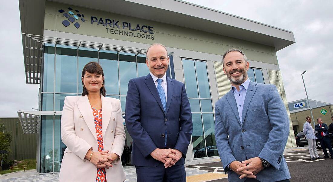 A woman and two men standing outside a building with the Park Place Technologies logo on it.